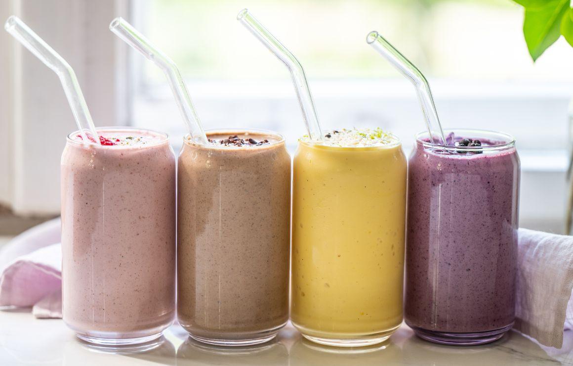 Vier Protein Shakes am Fenster in einer Reihe