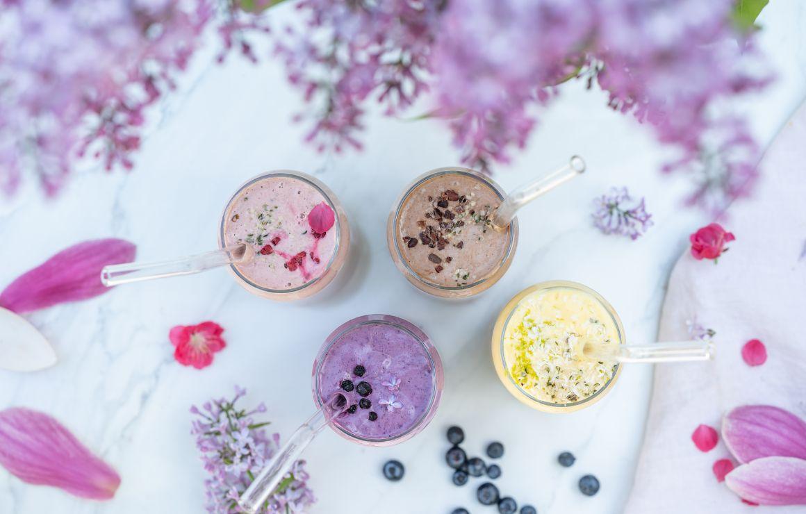Vier Protein Shake Rezepte - von oben auf einer weißen Tippplatte fotografiert