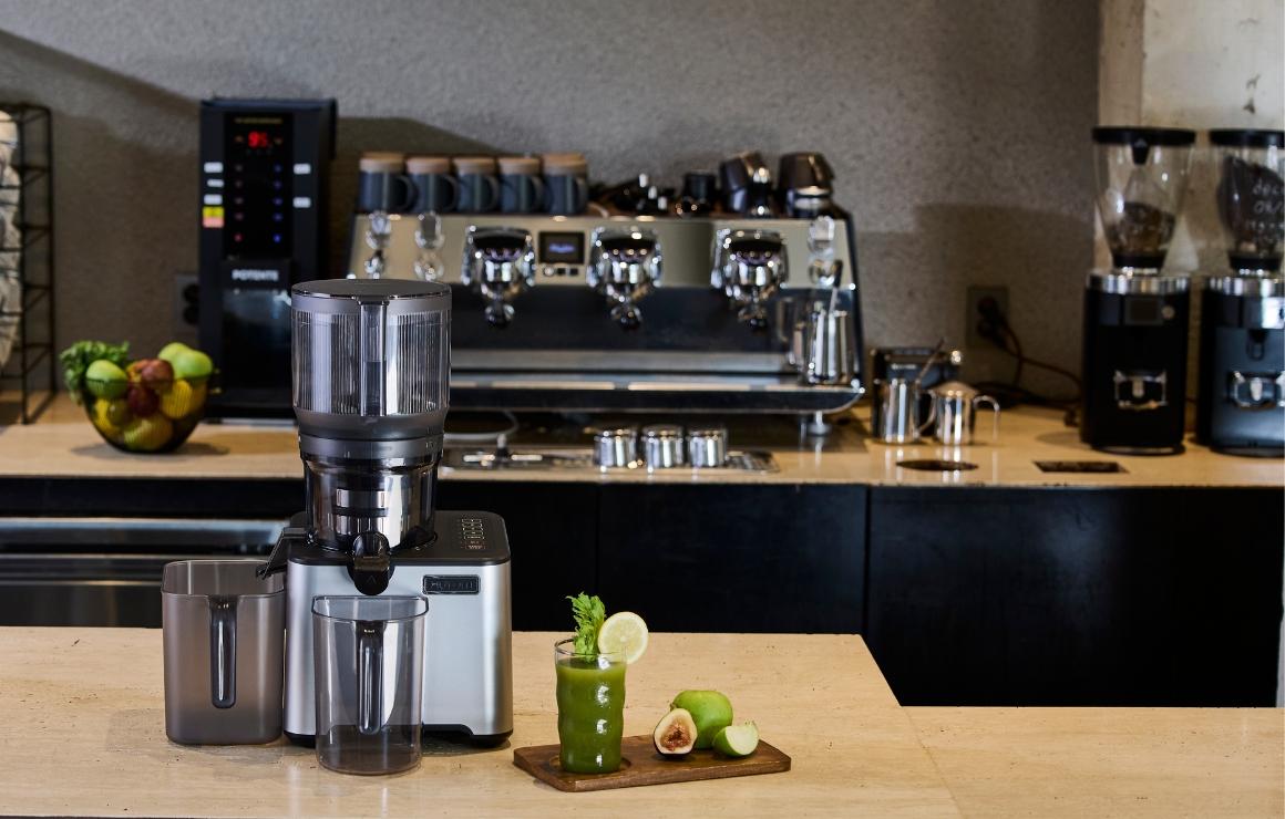 Hurom CP50 mit frisch entsaftetem grünem Saft im Café